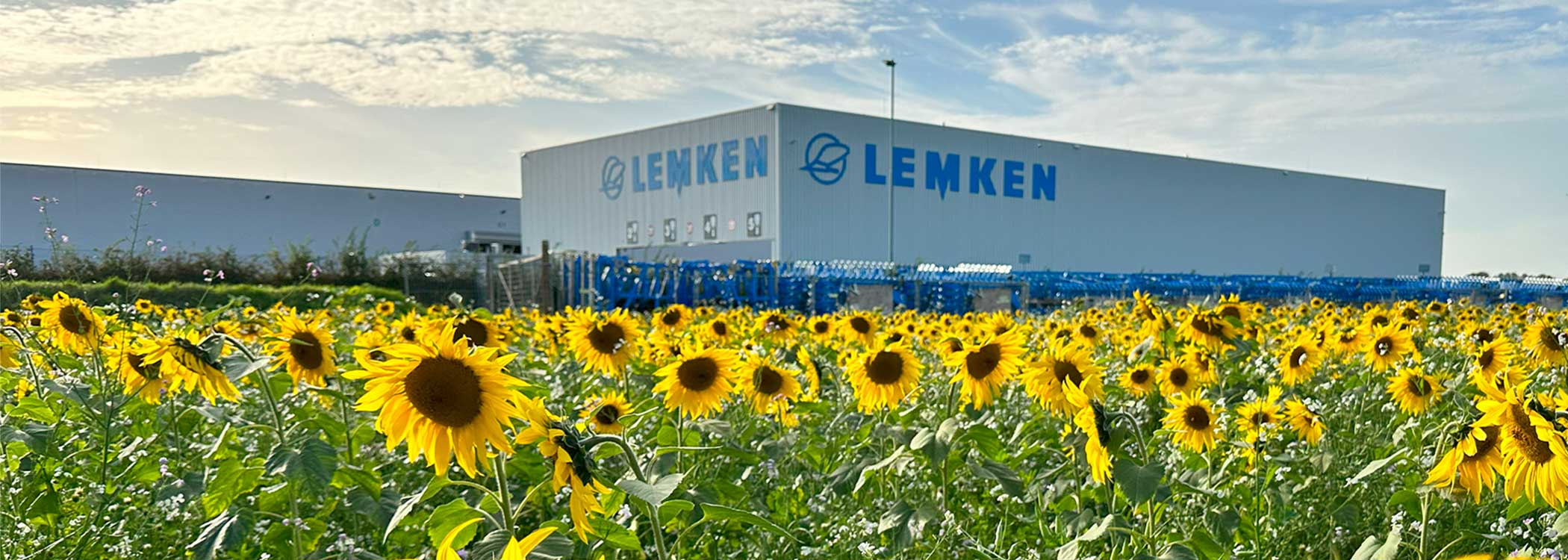 LEMKEN Werk Alpen hinter Sonnenblumenfeld